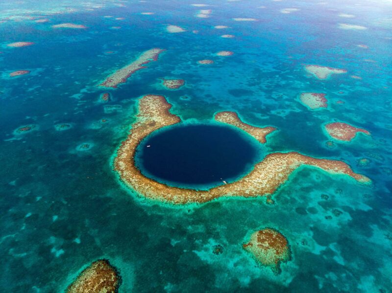 El sistema de arrecifes de barrera de Belice, que incluye una profunda cueva marina conocida como el Gran Agujero Azul, es el tema de un estudio reciente en el que los investigadores utilizaron 20 años de datos satelitales de la NASA para evaluar el riesgo para los arrecifes de coral de temperaturas más altas y aguas turbias. Crédito: Adobe Stock/James