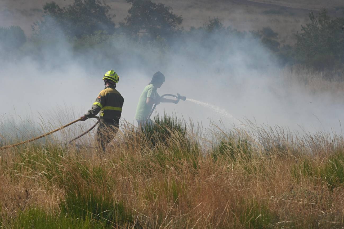 Bomberos forestales remojaban una zona ante el avance del incendio de Murias de Ponjos (León), el viernes pasado. / EFE | J.Casares